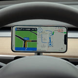 The Tesery Official Store Magsafe Wireless Charging Phone Holder for Model Y/3 Highland mounts on your dashboard, displaying GPS maps and directions through the steering wheel—ideal for Tesla drivers.